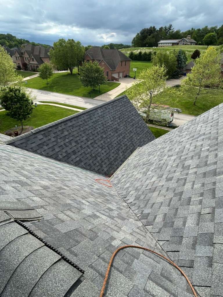 Finished gray architectural shingle roof on a high-end stucco home