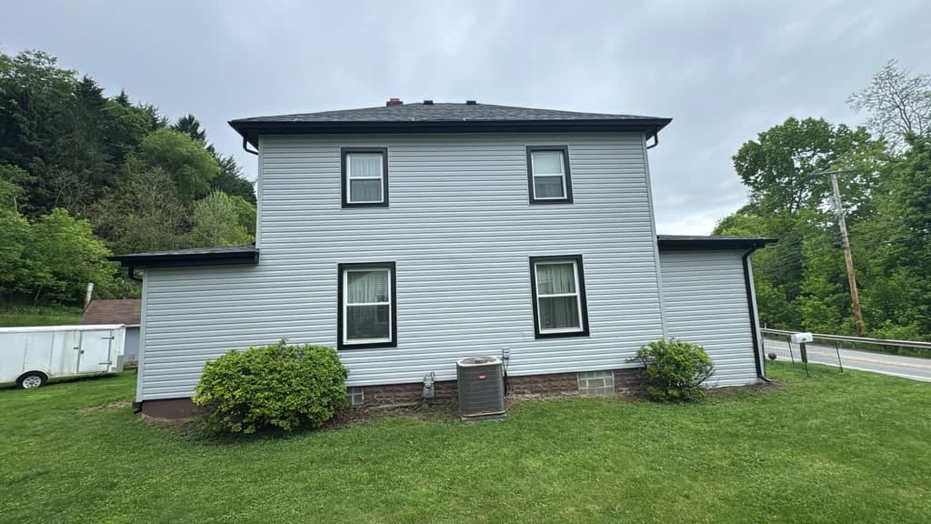 Back of a home with new white vinyl siding and black accent trim